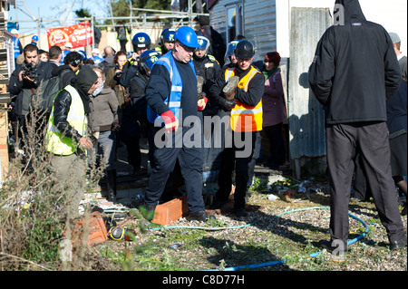 Dale Farm Räumung. Polizei und Gerichtsvollzieher führen ein Demonstrant, der festgenommen wurde. Stockfoto