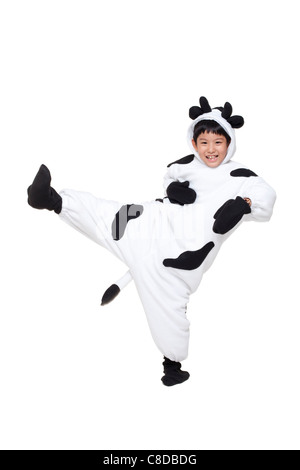 Gekleidet in eine Kuh-Kostüm in der Luft treten junge Stockfoto