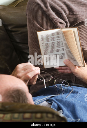 Mann liest Hardcover-Buch Stockfoto