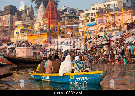 Touristen im Boot Werbung TATA Indicom am Fluss Ganges in Varanasi, Benares, Nordindien Stockfoto