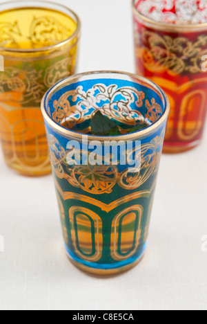 Kleine farbige Gläser Pfefferminztee auf weißem Hintergrund. Stockfoto