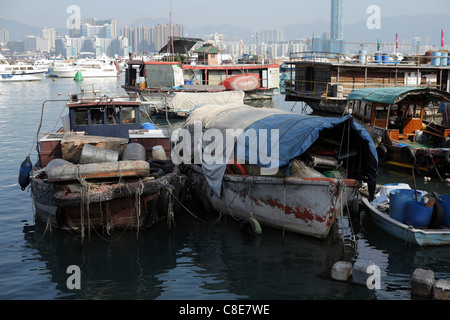 baufälliges Haus Arbeitsboote in Hong Kong Victoria Harbor, China, Asien. Mit wohlhabenden Wolkenkratzer Skyline hinter. Stockfoto