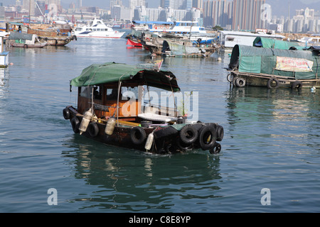 marode Angelboote/Fischerboote in Hong Kong Victoria Harbour mit Skyline der Stadt hinter China Stockfoto