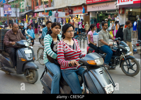 Junge indische Mädchen fahren Motorroller im Straßenbild in Stadt Varanasi, Benares, Nordindien Stockfoto