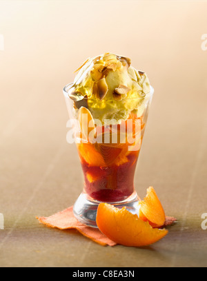 Gebratene Aprikosen mit Honig, dünn geschnitten, Mandeln, Vanille-Eis und roten Johannisbeeren pürieren Verrine Stockfoto