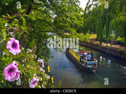 Bootstour auf dem Narrowboat mit Familienfahrt auf dem River Wey durch das Stadtzentrum von Guildford mit Blüte im Vordergrund Surrey England Stockfoto