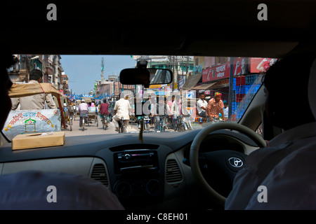 Beschäftigt Straßenszene angesehen durch Taxi Windschutzscheibe in Stadt Varanasi, Benares, Nordindien Stockfoto