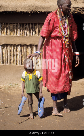 Lolgorian, Kenia. Siria Maasai Manyatta; Frau und Kleinkind, traditionelle Perlenarbeiten Ohrringe blaue Kunststoff-Schuhe. Stockfoto