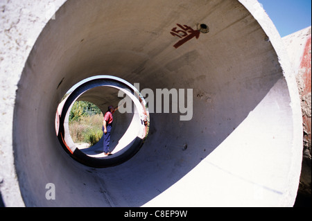 Belgrad, Serbien, Jugoslawien. Wasser Behandlung Unternehmen; Mann im Inneren einer riesigen Rohr prüfen. Stockfoto