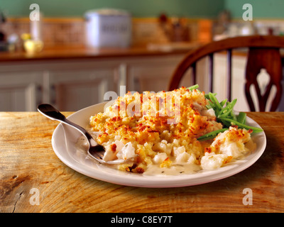 Traditionelle britische ofengebackene Kartoffel fisch Kartoffel Torte serviert auf einem weißen Teller auf einem Tisch in einem traditionellen Küche einstellen Stockfoto
