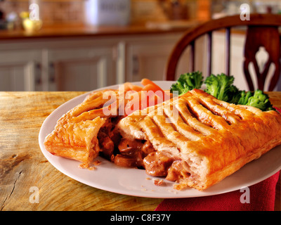 Traditionelles Steak-Gitter-Pie-Gericht mit gebratenen Kartoffeln Auf einem Teller in einer rustikalen Küche Stockfoto