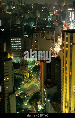 Sao Paulo, Brasilien. Übersicht über Hochhaus Büro- und Wohngebäude in der Innenstadt in der Nacht mit kolonialen Kirche. Stockfoto