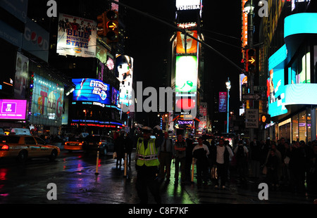 Nachtaufnahme Polizist Regie Verkehr nass Neon Asphalt Menschen Kreuzung Straße, West 45th Street 7th Avenue, Times Square, New York Stockfoto