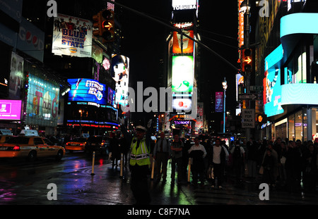 Nacht erschossen Menschen Kreuzung Straße Polizist regelt den Verkehr nass Neon Asphalt West 45th Street 7th Avenue, Times Square, New York Stockfoto