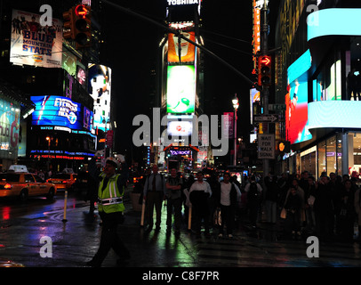 Nacht erschossen Polizisten gelbe Jacke Regie Verkehr grün Neon nassen Asphalt, West 45th Street 7th Avenue, Times Square, New York Stockfoto