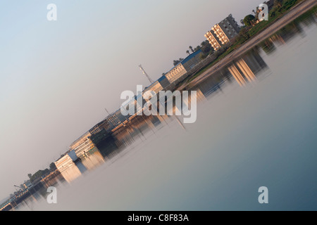 Redundante Kreuzfahrtschiffe vor Anker in der Nähe von Industriebauten auf dem Nil reflektierenden im goldenen Wasser, diagonal in Schuss gebracht Stockfoto