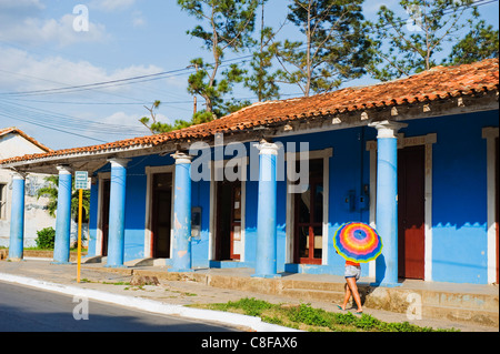 Frau mit Sonnenschirm, vorbei an einem bunten Gebäude, UNESCO-Weltkulturerbe, Tal von Vinales, Kuba, Karibik, Caribbean Stockfoto