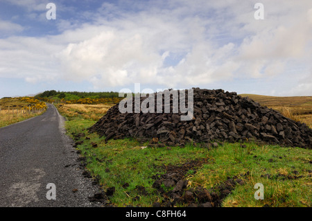 Haufen von Torf oder Rasen an der Seite der Straße im County Galway, Irland Stockfoto