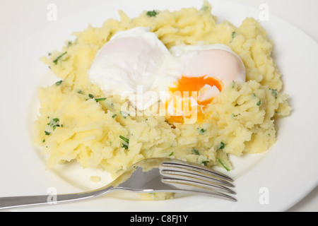 Eine schnelle und kostengünstige Mahlzeit pochierte Eier in einem Nest aus gestampften Petersilienkartoffeln Stockfoto