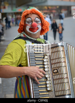 Straßenmusik Clown mit Akkordeon Stockfoto