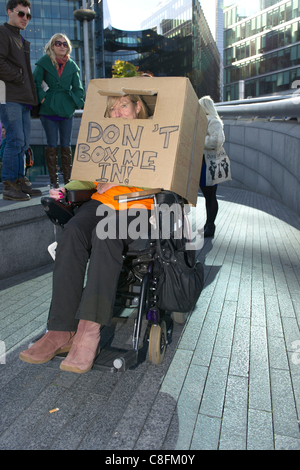 Samstag, 22. Oktober 2011, Queens Way, London. Ein Rollstuhl gebunden Frau trägt ein Karton auf dem Kopf auf einer Kundgebung gegen die Kürzungen, die lebenden Behindertenbeihilfe vorgeschlagen durch die Regierung. Stockfoto
