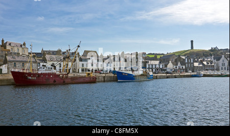 Trawler gefesselt am Hafen Kai in Macduff Aberdeenshire mit der Macduff Krieg Denkmal achteckigen Turm hinter auf Hügel. Stockfoto