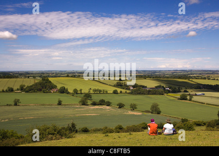 Paar-Sitzung mit einem Picknick nahe dem Gipfel des Hügels Burrough mit weit reichenden Blick über ländliche Leicestershire, England, UK Stockfoto