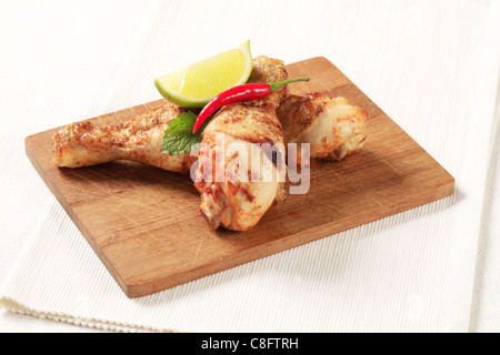 Zwei gebratene Hähnchen Drumsticks auf ein Schneidebrett Stockfoto