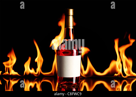 Flasche Wein Schnaps mit Feuer Flammen im Hintergrund Stockfoto