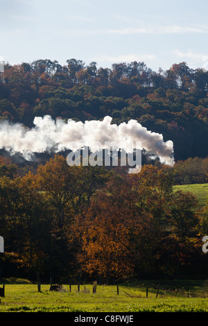 Alte Dampflok zieht Fracht durch ländliche Landschaft im Herbst Stockfoto