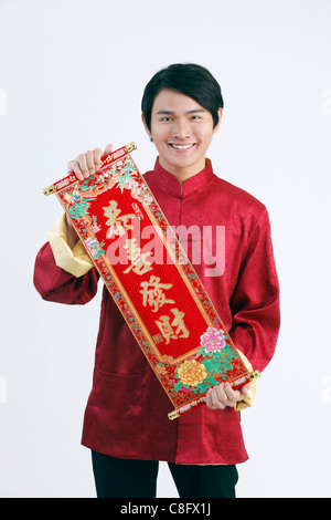 Junger Mann im Kostüm präsentieren chinesische Glück Gedicht Stockfoto