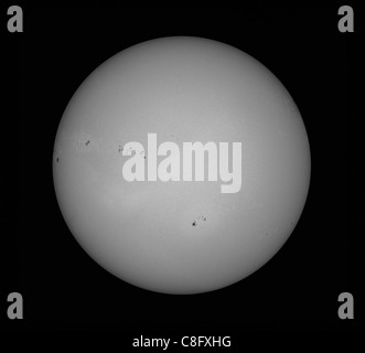 Die Sonne fotografiert in weißem Licht zeigt zahlreiche Sonnenflecken auf der Oberfläche Stockfoto