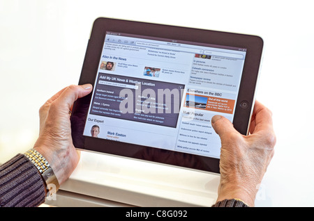 Ältere Frau, die mit dem iPad Stockfoto