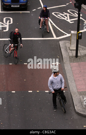 Blick hinunter auf 3 Radfahrer warten an der Ampel in London Stockfoto