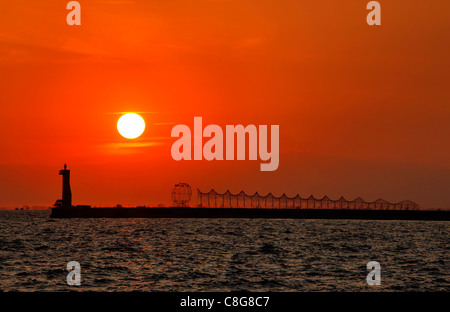 Eine künstlerische Installation und der Leuchtturm an der Mole von Thessaloniki Hafen bei Sonnenuntergang. Makedonien, Griechenland. Stockfoto