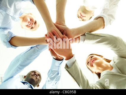 Vier Geschäftsleute, legte ihre Hände auf Händen ihrer Kollegen Stockfoto