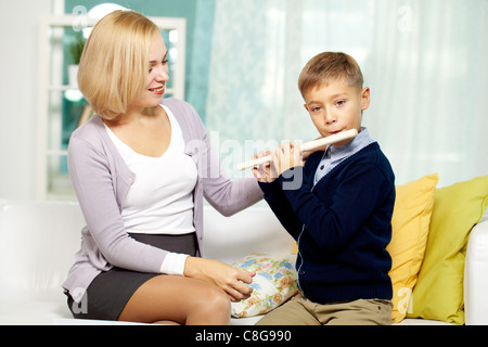 Porträt von hübschen Tutor betrachten ihre fleißige Schülerin beim Flötenspiel Stockfoto