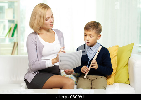 Porträt von hübschen Tutor zeigt Notizen fleißige Schüler mit Querflöte Stockfoto