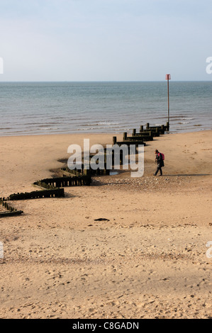 Walker, nähert sich eine Buhne am Strand von Hunstanton in Norfolk, Großbritannien Stockfoto