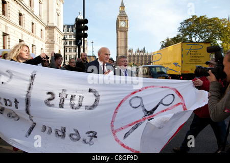 Vince Cable, der Wirtschaftsminister wird von Demonstranten gegen "Körperschaftsteuer ausweichen", wie er von Whitehall, Victoria Street, Central London, UK, auf Montag, 24. Oktober 2011 geht konfrontiert. Stockfoto