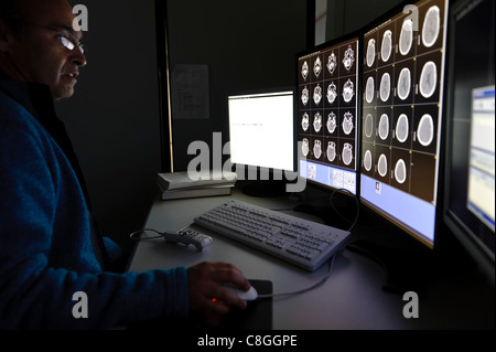 Arzt untersucht CT Gehirn-Scan auf Computer-Bildschirmen Stockfoto
