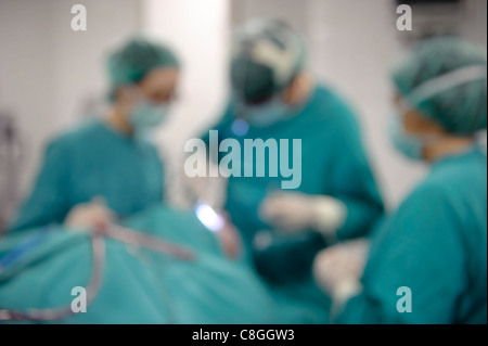 Drei verschwommene Ärzte der Chirurgie im Krankenhaus-OP-Saal Stockfoto