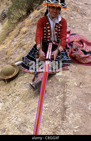 Pisac, Urubamba (Vilcanota) Tal, Peru. Lächelnde Frau in bunten Trachten weben einen Gurt. Stockfoto