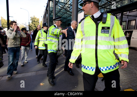 Vince Cable, der Wirtschaftsminister wird von Demonstranten gegen "Körperschaftsteuer ausweichen", wie er von Whitehall, Victoria Street, Central London, UK, auf Montag, 24. Oktober 2011 geht konfrontiert. Stockfoto