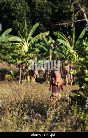 Ein junger madagassischen Mann trägt eine Mädchen auf seinen Schultern zurück zu ihrer Hütte in der Mitte der Insel Nosy Sakatia, in der Nähe von Nosy Be Stockfoto