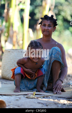 Ein junges Mädchen und ihre Großmutter mit traditionellen Frisuren vor ihrer Hütte in Nosy Sakatia, in der Nähe von Nosy Be (Nossi-Bé), Madagaskar Stockfoto