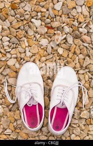 Weiße Sommerschuhe auf Steinen Stockfoto