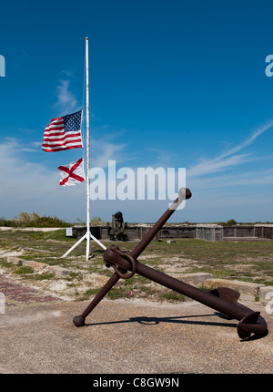 Die Flagge der Vereinigten Staaten von Amerika und die Flagge auf Halbmast-Bundesstaat Alabama in der Nähe von einem Schiffe Anker im historischen Fort Stockfoto