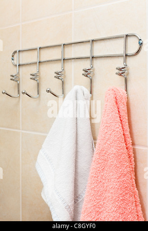 Zwei Frottierwäsche hängt an einem Haken im Bad. Weiß und rosa Stockfoto