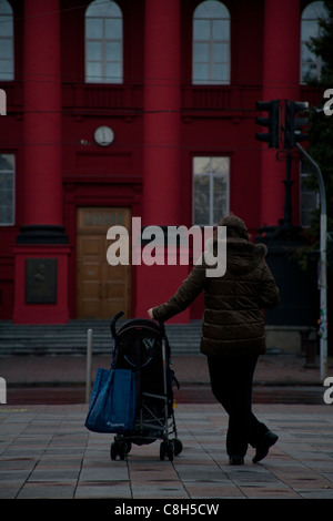 Frau mit einem Kinderwagen außerhalb der roten Universität Gebäude von Taras Shevchenko nationale Universität von Kiew, Kiew, Ukraine Stockfoto